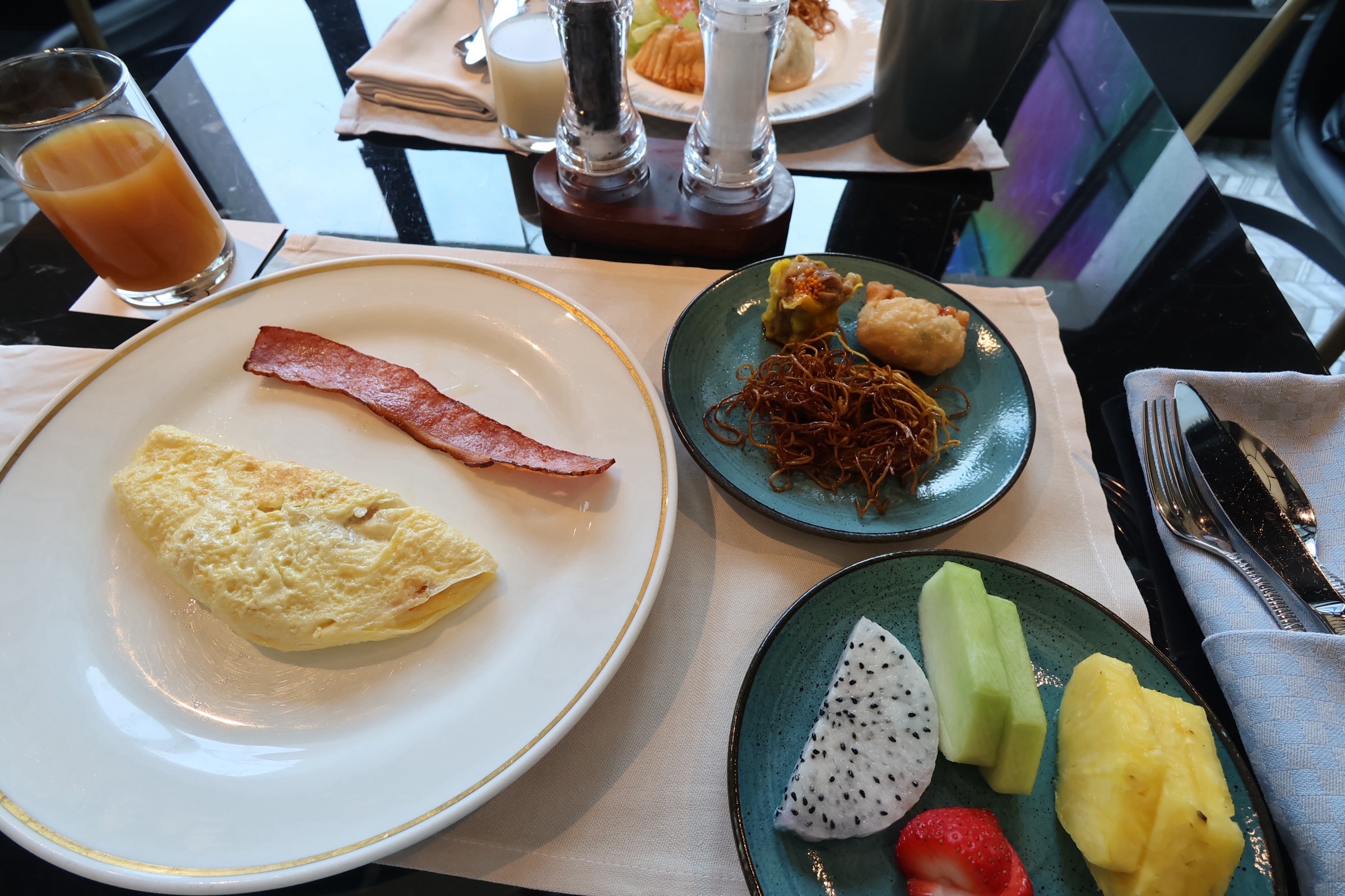 ラウンジ朝食のオムレツとベーコン、麺料理、フルーツ