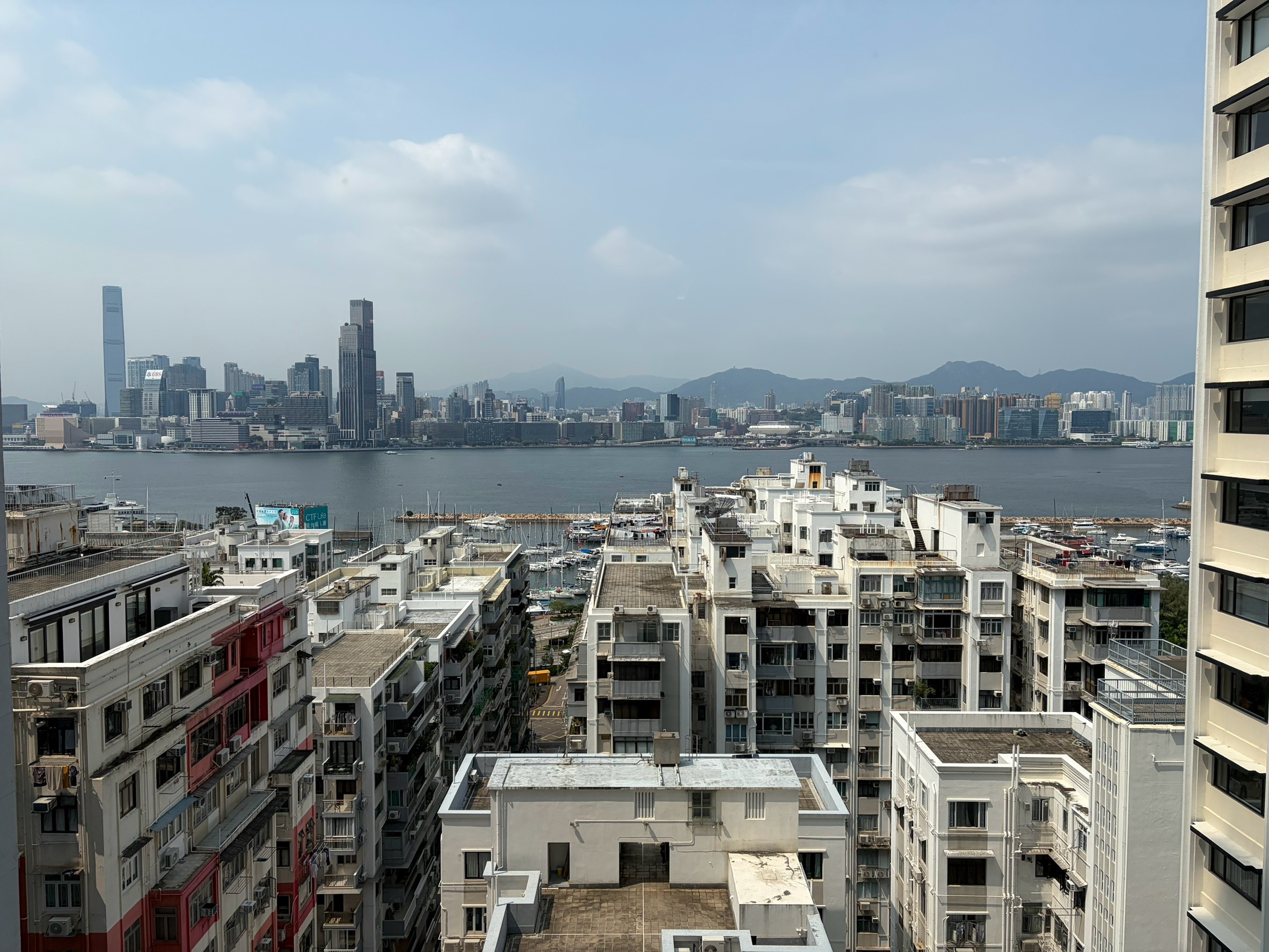 プレミアムルームの窓から見える香港の街並みと海、対岸の高層ビル